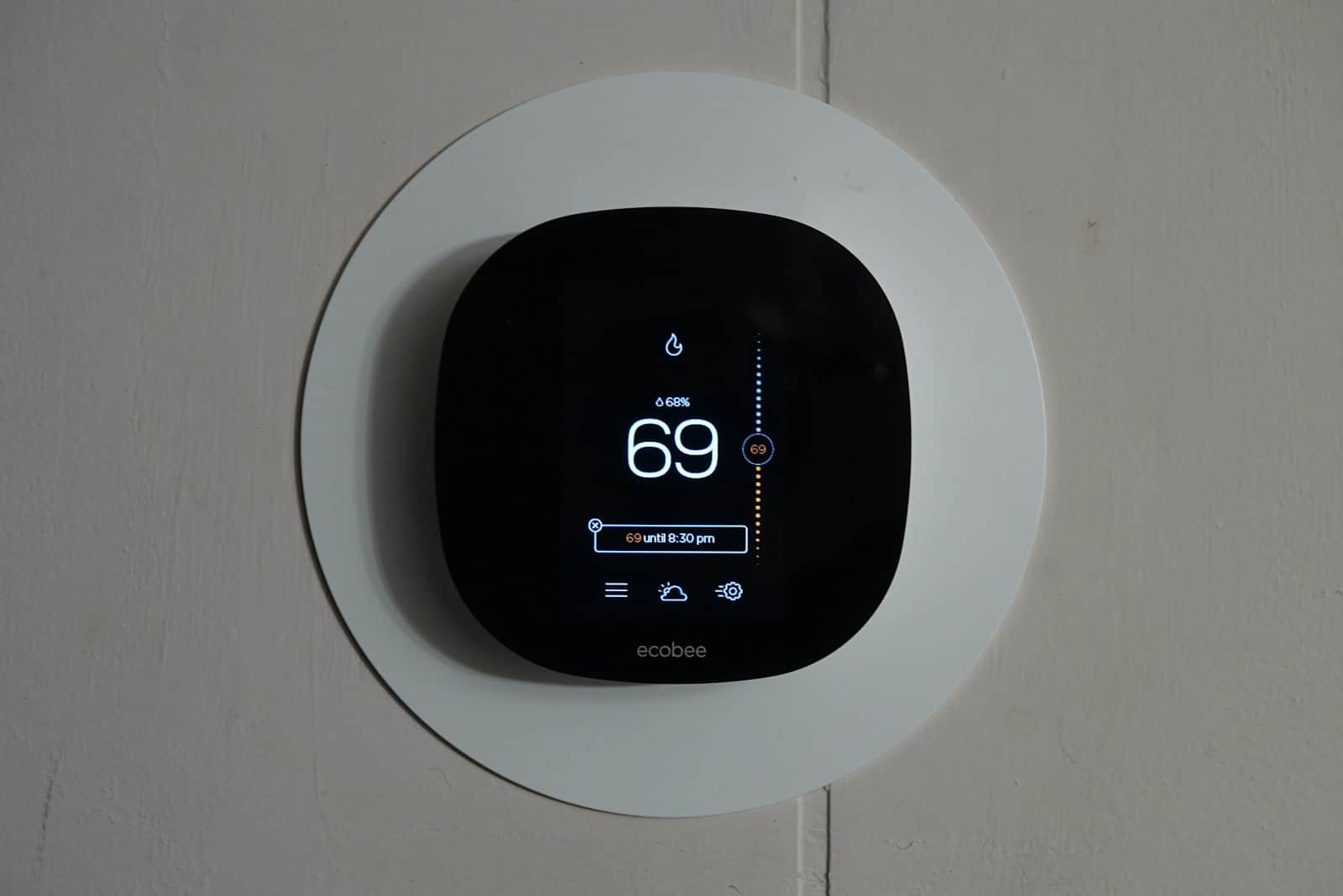 ecobee smart thermostat on a wall, cool blue display reading 69 degrees